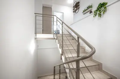 a staircase with a metal railing in a house at Sky Loft near Center 220m, AC, PS5, Free Parking in Prague