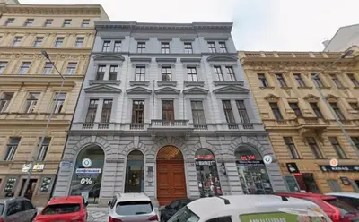 a building with cars parked in front of it at Bright Apartment near Main Station in Prague