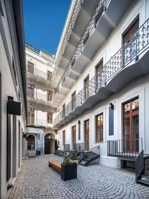 an empty courtyard of a building with stairs and benches at Bright Apartment near Main Station in Prague
