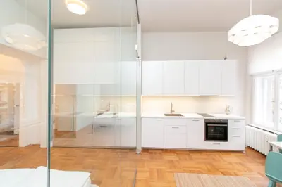a kitchen with white cabinets and a glass shower at Elegant,Bright,Best location in Prague