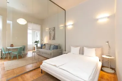 a bedroom with a large white bed and a living room at Elegant,Bright,Best location in Prague