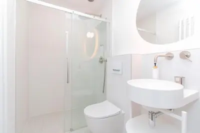 a white bathroom with a shower and a toilet and sink at Elegant,Bright,Best location in Prague