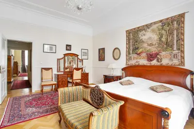 a bedroom with a bed and a chair at Prague Imperial Heritage in Prague