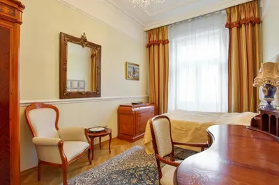 a bedroom with a bed and a table and a mirror at Prague Imperial Heritage in Prague