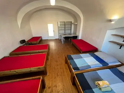 a room with three bunk beds and a desk at Artillery Barracks Accommodation in Terezín