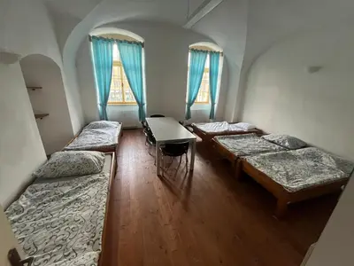 a room with three beds and two windows at Artillery Barracks Accommodation in Terezín