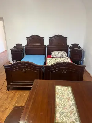 two twin beds in a room with a table at Artillery Barracks Accommodation in Terezín