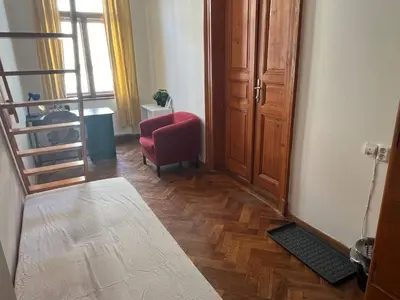 a living room with a red chair and a stair case at Central cozy rooms Soukenická S34 in Prague