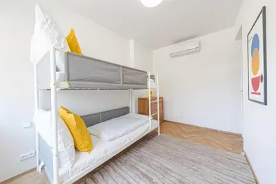 a small room with a bunk bed with yellow pillows at Sky Apartment Residence in Prague