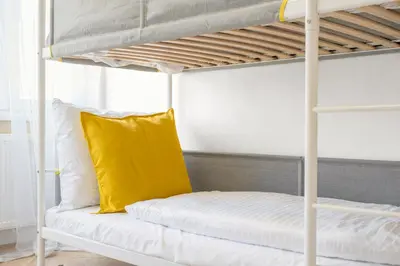 a white bunk bed with a yellow pillow on it at Sky Apartment Residence in Prague