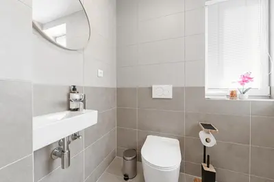 a bathroom with a toilet and a sink and a mirror at Sky Apartment Residence in Prague