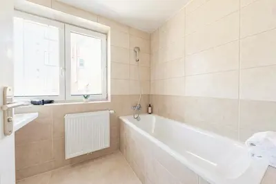 a bathroom with a white tub and a window at Sky Apartment Residence in Prague