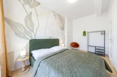 a bedroom with a green bed with a wall mural at Sky Panorama Villa in Prague