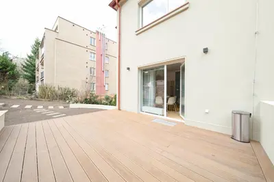 a patio with a wooden floor and a building at Sky Panorama Villa in Prague