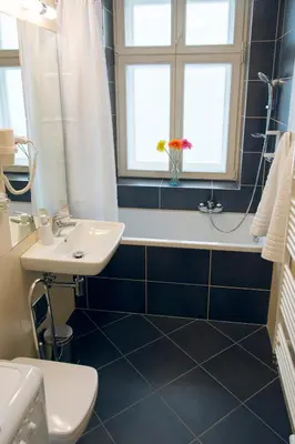 a bathroom with a sink and a tub and a toilet at Limes Apartments in Prague