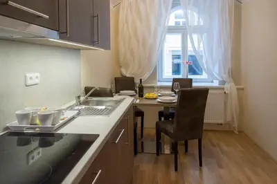 a kitchen with a sink and a table with a window at Limes Apartments in Prague