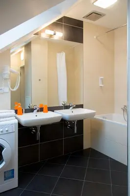 a bathroom with two sinks and a tub and a mirror at Limes Apartments in Prague