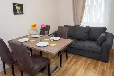 a dining room table with chairs and a couch at Limes Apartments in Prague