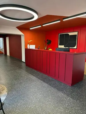 an office with a red wall with a tv on it at ObriyPraha in Prague