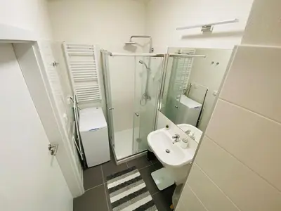 a white bathroom with a sink and a mirror at Cozy Studio Prague 5 Easy Access to CityCenter in Prague