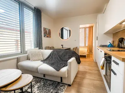 a living room with a couch and a table at Bright Modern 1BR • Quiet • 20 min Center • Grill in Prague