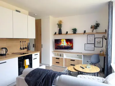 a living room with a couch and a table with a fireplace at Bright Modern 1BR • Quiet • 20 min Center • Grill in Prague