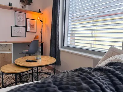 a bedroom with a bed and a table and a desk at Bright Modern 1BR • Quiet • 20 min Center • Grill in Prague