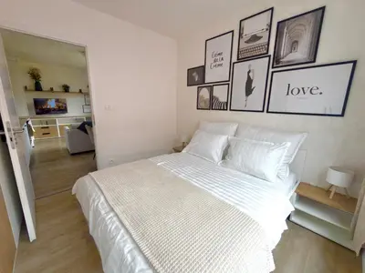 a white bed in a room with pictures on the wall at Bright Modern 1BR • Quiet • 20 min Center • Grill in Prague