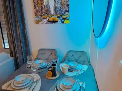 a table with plates and wine glasses on it at Bright Modern 1BR • Quiet • 20 min Center • Grill in Prague