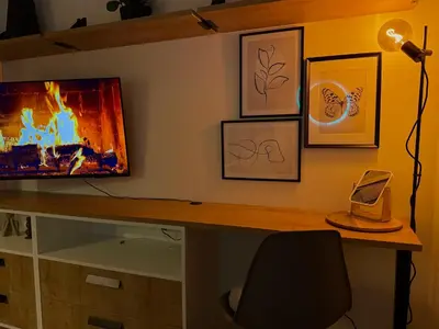 a desk with a tv on a wall with pictures at Bright Modern 1BR • Quiet • 20 min Center • Grill in Prague