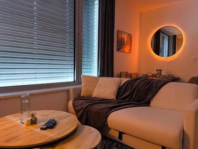 a living room with a couch and a table at Bright Modern 1BR • Quiet • 20 min Center • Grill in Prague