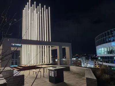 a lit up building with a table and chairs on a balcony at Bright Modern 1BR • Quiet • 20 min Center • Grill in Prague