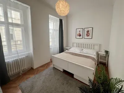 a bedroom with a bed and two windows at Opatovicka Central Living in Prague