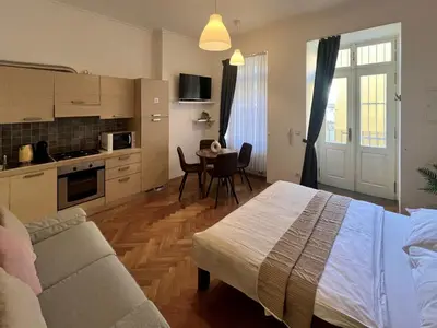 a bedroom with a bed and a kitchen with a table at Opatovicka Central Living in Prague