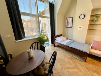 a room with a table and a bed and a window at Opatovicka Central Living in Prague