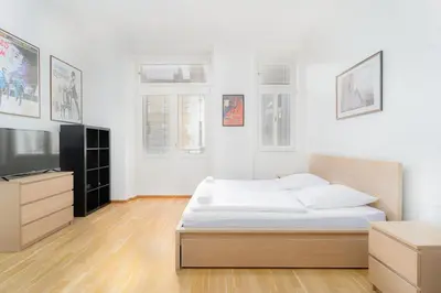 a bedroom with a bed and a flat screen tv at Bright 1 BR, close to Malá Strana & Dancing House in Prague