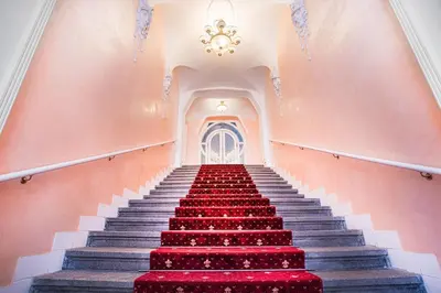 a staircase with red carpeting and a chandelier at Bright 1 BR, close to Malá Strana & Dancing House in Prague