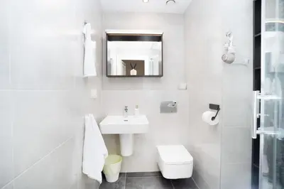 a white bathroom with a sink and a toilet at Bright 1 BR, close to Malá Strana & Dancing House in Prague