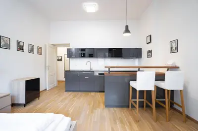 a kitchen with a table and chairs in a room at Bright 1 BR, close to Malá Strana & Dancing House in Prague
