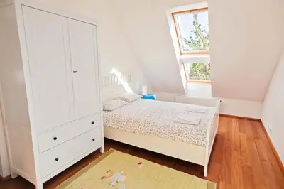 a bedroom with a bed and a large white cabinet at Guest House Villa Monet in Prague