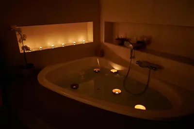 a bathroom with a bath tub with candles in it at Cozy Private Studio for Couples & Solo Travelers in Prague