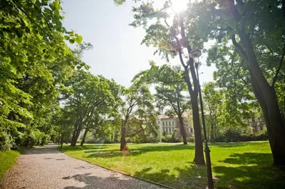 a path in a park with trees and a building at Cozy Private Studio for Couples & Solo Travelers in Prague