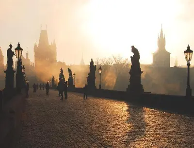 a crowd of people walking in a city at sunset at Cozy Private Studio for Couples & Solo Travelers in Prague