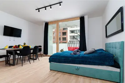 a bedroom with a bed and a dining room at New Bohemian Apartment in Prague