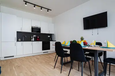 a kitchen with a table and chairs and a television at New Bohemian Apartment in Prague