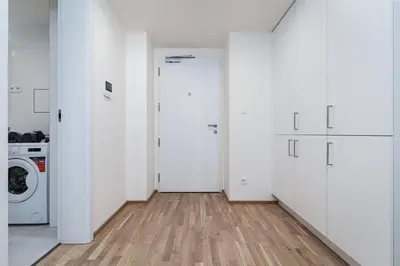 a room with white cabinets and a washer and dryer at New Bohemian Apartment in Prague
