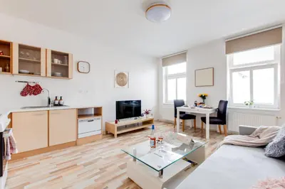 a living room with a couch and a table at Comfy Apartment with Bedroom Nook in Prague