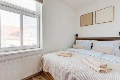 a white bedroom with a bed with towels on it at Comfy Apartment with Bedroom Nook in Prague