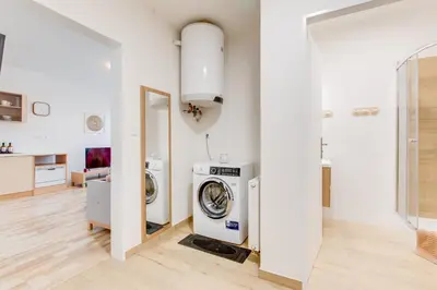 a laundry room with a washer and dryer at Comfy Apartment with Bedroom Nook in Prague