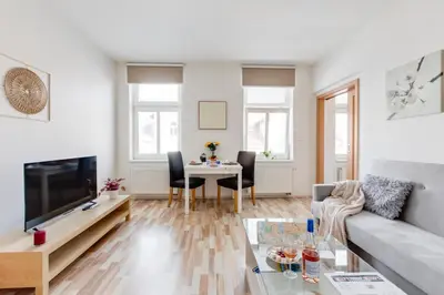 a living room with a couch and a table at Comfy Apartment with Bedroom Nook in Prague